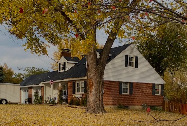 A midwestern house during autumn with a large tree in front.
