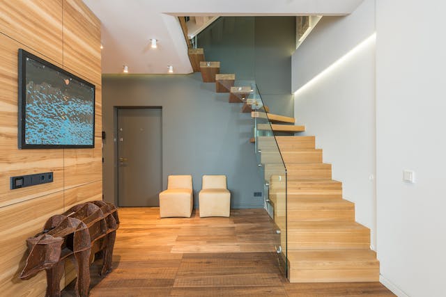 interior of a luxury home with wood floors and a large staircase
