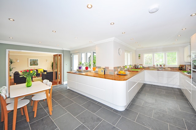 interior of a white and wood kitchen with grey tile flooring