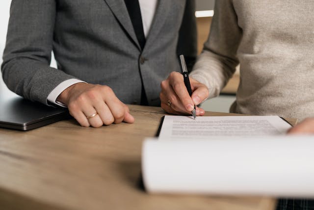 two people in suits signing a contract